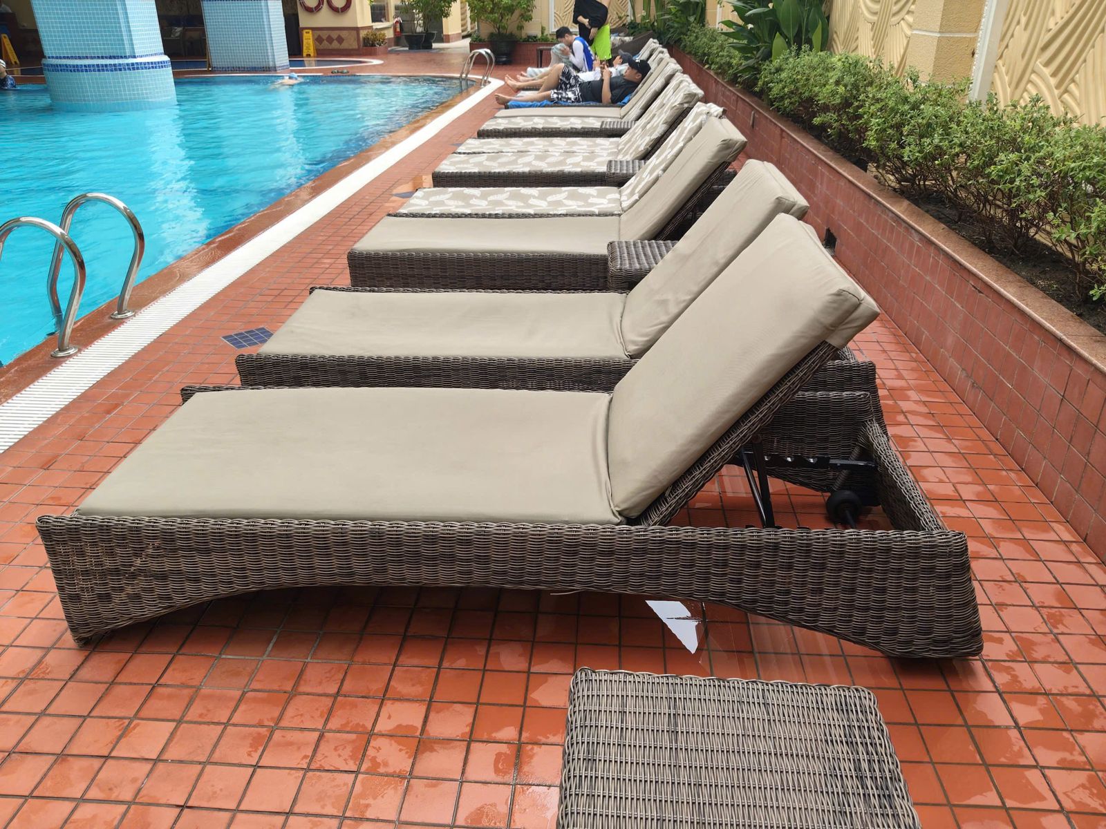 Dãy ghế nằm đan mây bên hồ bơi resort